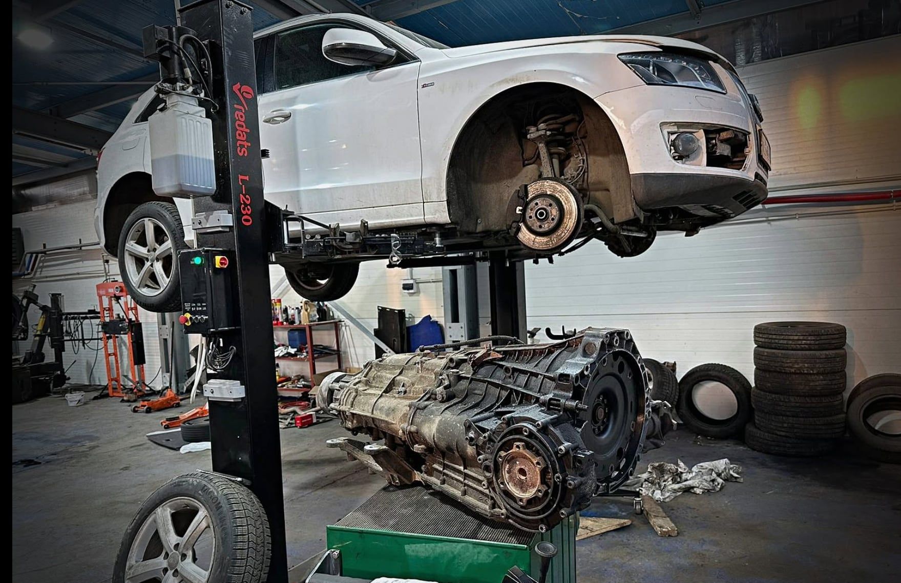 Audi Q5 na podnośniku, obok wymontowana skrzynia biegów